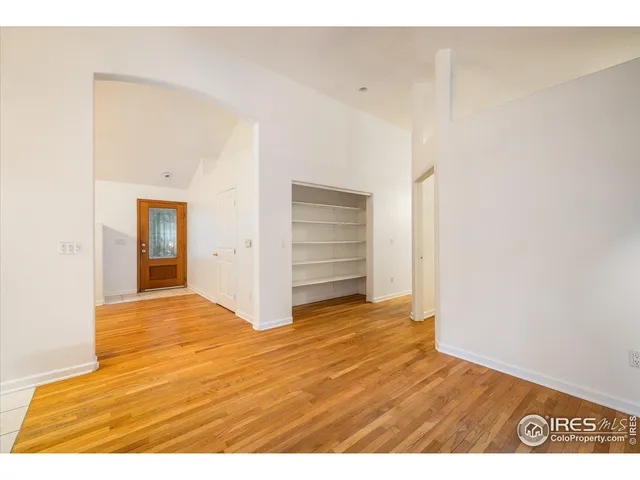 a view of an empty room with closet and bathroom