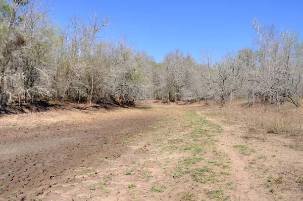 a view of dirt road with a building in the background