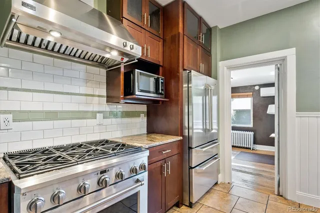 a kitchen with stainless steel appliances granite countertop a stove and a refrigerator