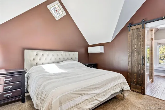 a large bed sitting in a bedroom next to a window