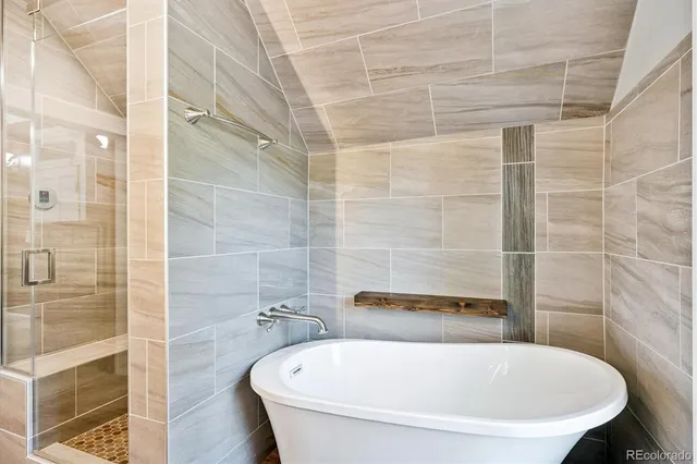 a white bath tub sitting next to a shower