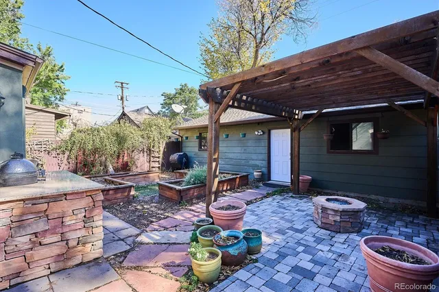 a view of a backyard with table and chairs potted plants