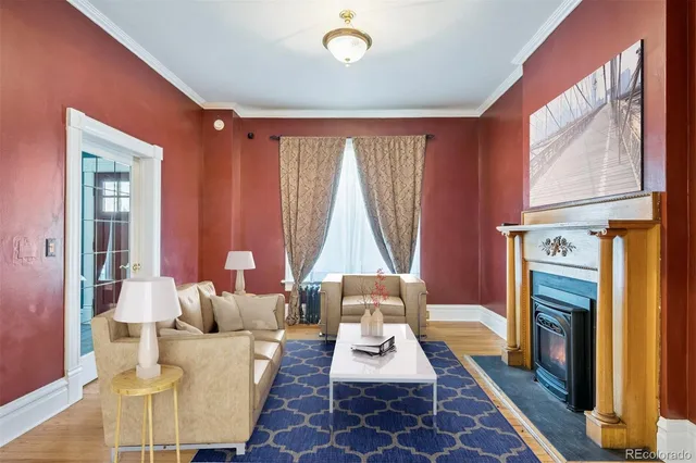 a living room with furniture a fireplace and large window