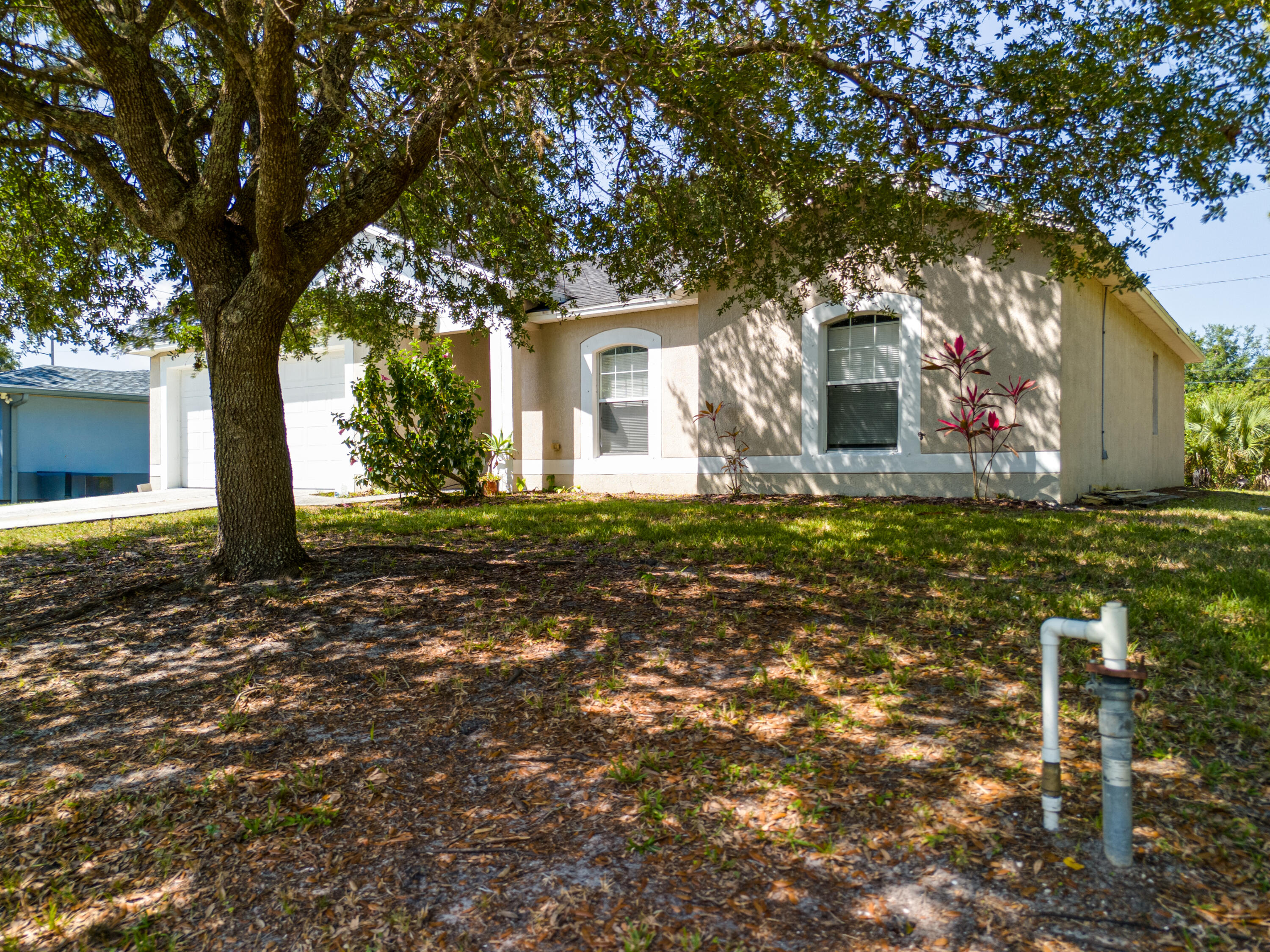 500 Topeka Road Southwest Palm Bay, FL 32908 - Photo 2 of 12 a front view of a house with a yard and large trees