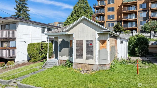 a view of a house with brick walls and a yard with plants