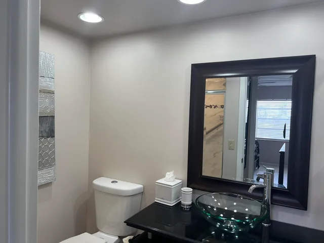 a bathroom with a toilet a sink and mirror