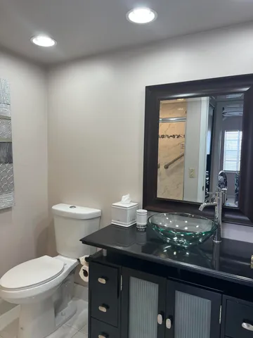 a bathroom with a toilet a sink and mirror