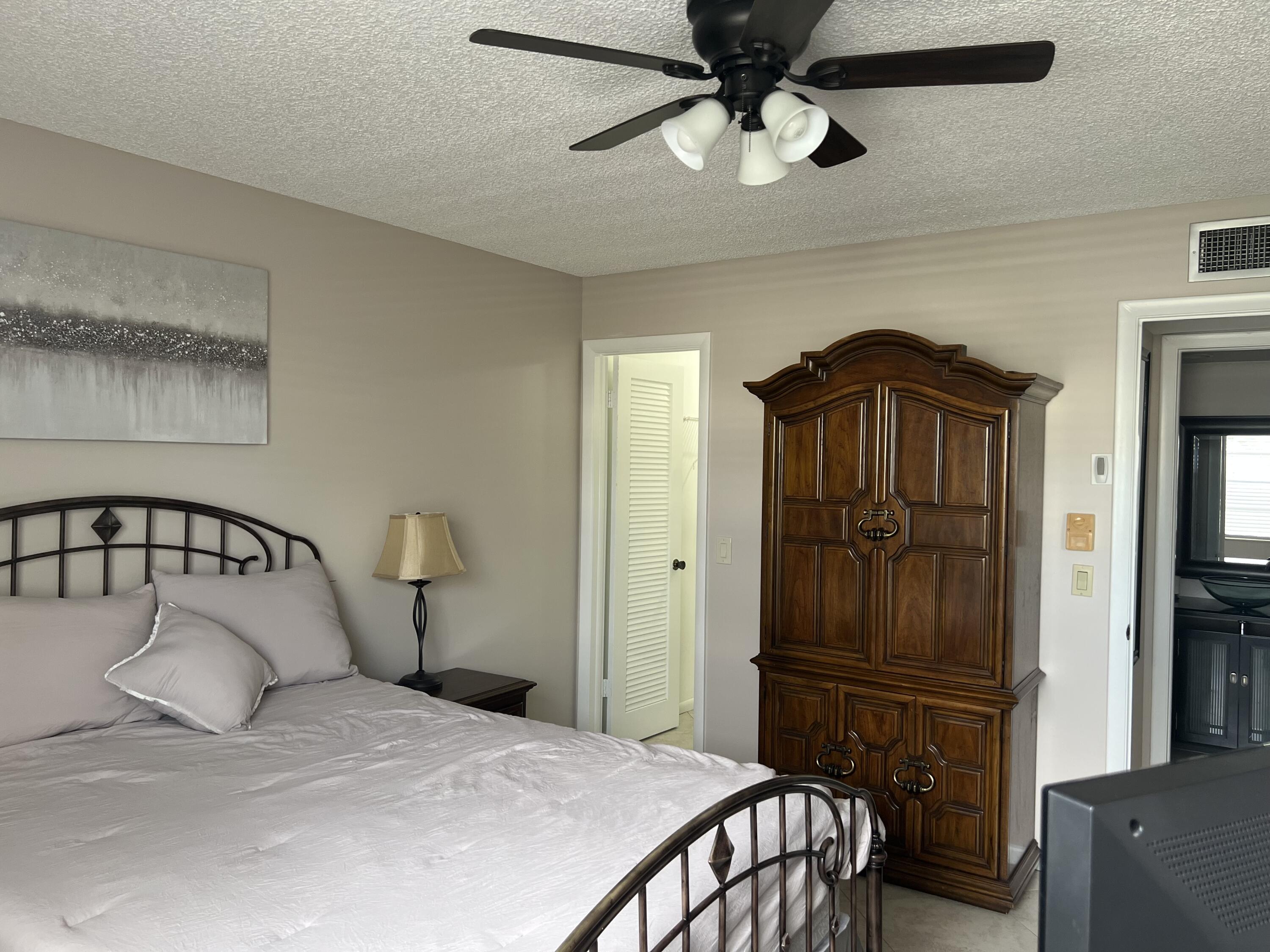 900 Flanders South Delray Beach, FL 33484 - Photo 21 of 52 a bedroom with a bed and a chandelier