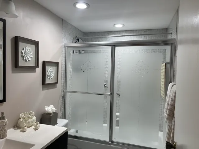 a bathroom with a mirror shower and toilet