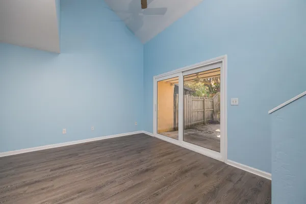 an empty room with wooden floor and sliding door