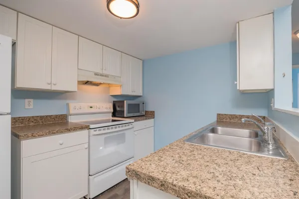 a kitchen with cabinets appliances and a sink