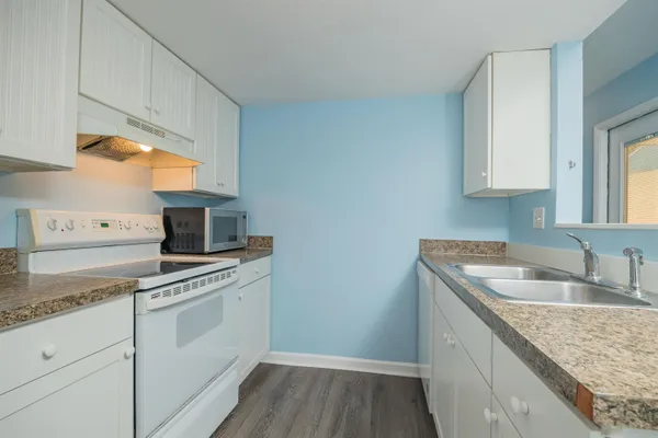 a kitchen with granite countertop a sink stove and cabinets