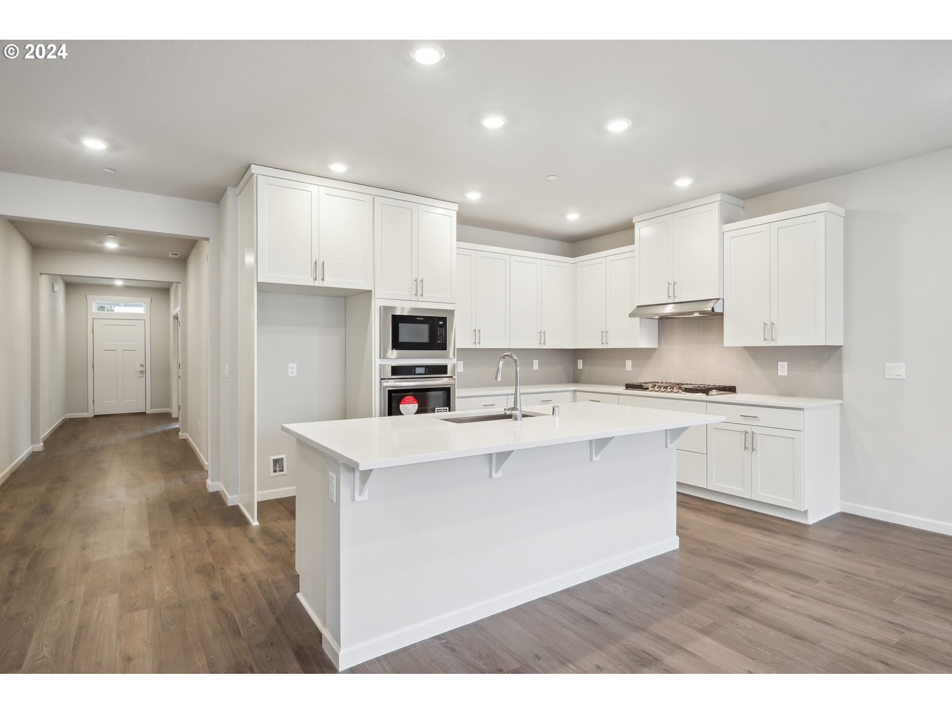 2706 South 7th Circle Ridgefield, WA 98642 - Photo 15 of 26 a open kitchen with stainless steel appliances granite countertop a sink a stove a refrigerator and white cabinets with wooden floor
