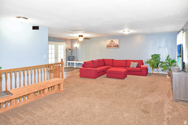 315 Park Street Inkom, ID 83245 - Photo 2 of 28 Spacious living area featuring light blue walls, brown carpeting, an open wooden railing, and ceiling-mounted light fixtures