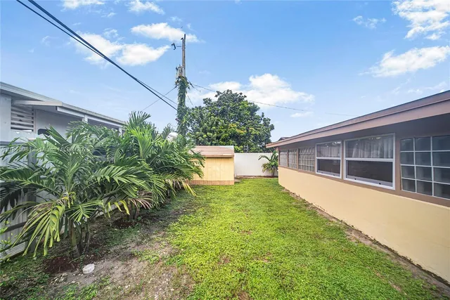 a backyard of a house with plants and outdoor seating