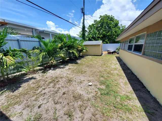 a backyard of a house with table and sofas