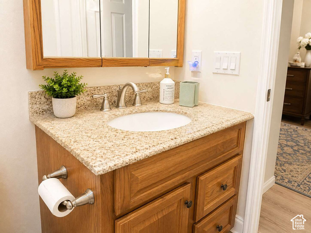 1526 North Dixie Downs Road, Unit 29 St. George, UT 84770 - Photo 13 of 16 Wood-finish vanity with an integrated sink, granite-style countertop, and brushed nickel hardware
