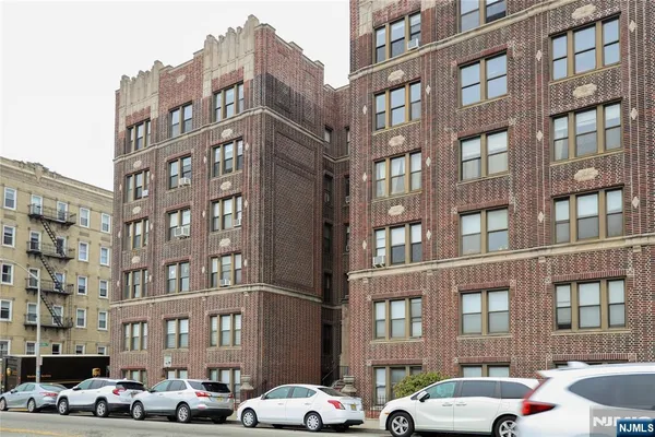 a front view of a building with lot of cars parked