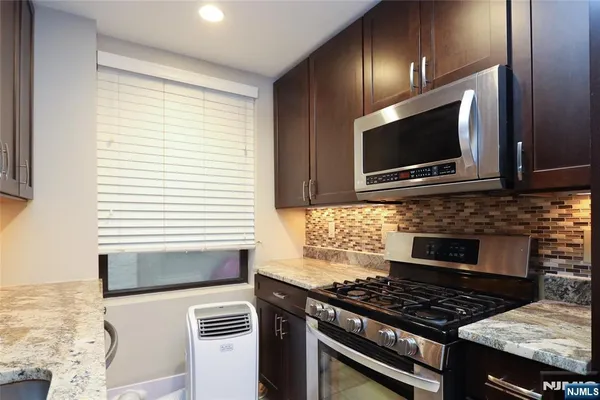 a kitchen with granite countertop a stove and a microwave