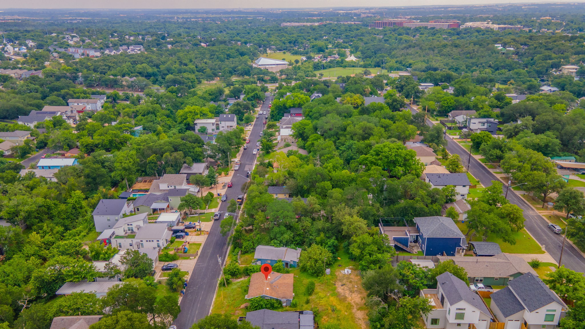 1410 Luna Street Austin, TX 78721 - Photo 5 of 5 An aerial perspective reveals a tree-lined neighborhood with a mix of residential structures and verdant landscapes.
