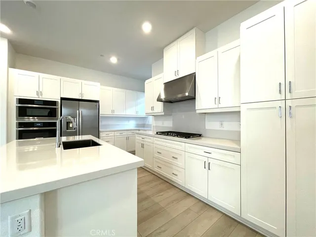 a kitchen with stainless steel appliances a stove a refrigerator and cabinets