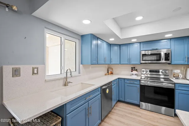 a kitchen with stainless steel appliances granite countertop a sink and a microwave