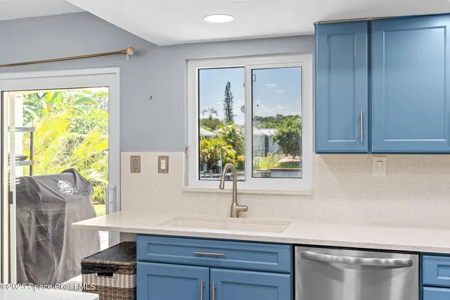a large kitchen with a table chairs and flat screen tv