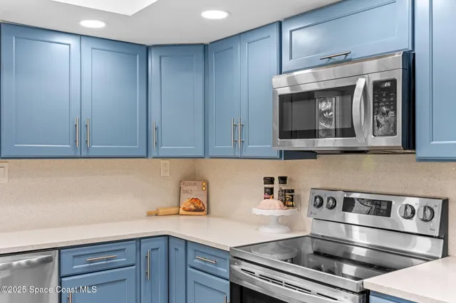 a kitchen with stainless steel appliances granite countertop a dining table chairs refrigerator sink and cabinets