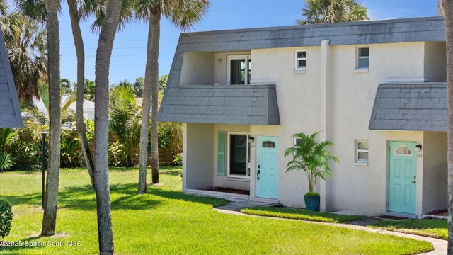 a view of a house with a yard and potted plants