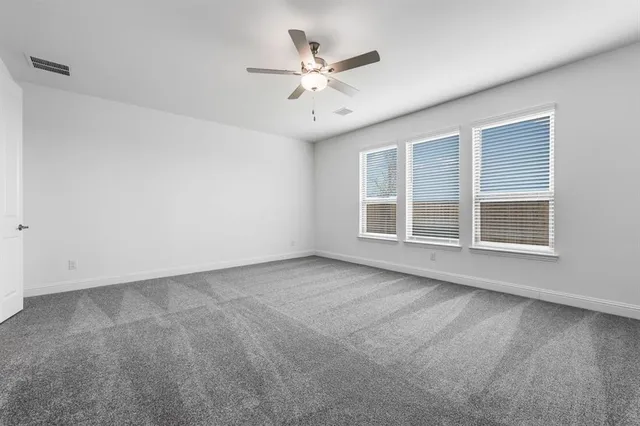 an empty room with window and ceiling fan
