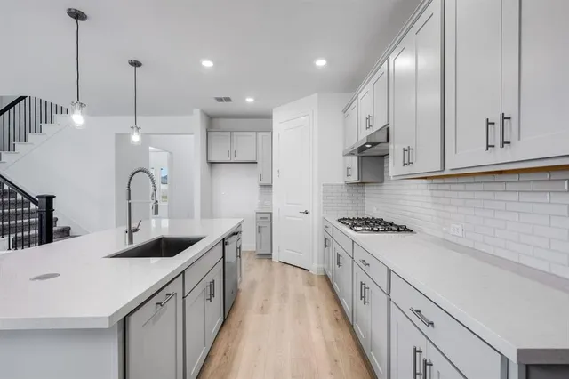 a kitchen with kitchen island granite countertop a sink stainless steel appliances and cabinets