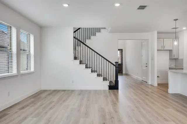 a view of a hallway with wooden floor and entryway