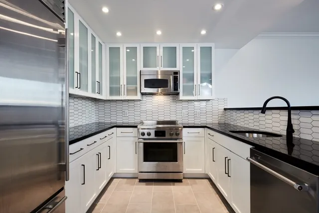 a kitchen with stainless steel appliances granite countertop a stove and a sink