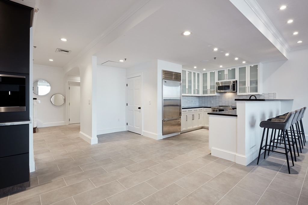 234 Causeway Street, Unit 913/813 Boston, MA 02114 - Photo 17 of 22 a open kitchen with white cabinets and stainless steel appliances