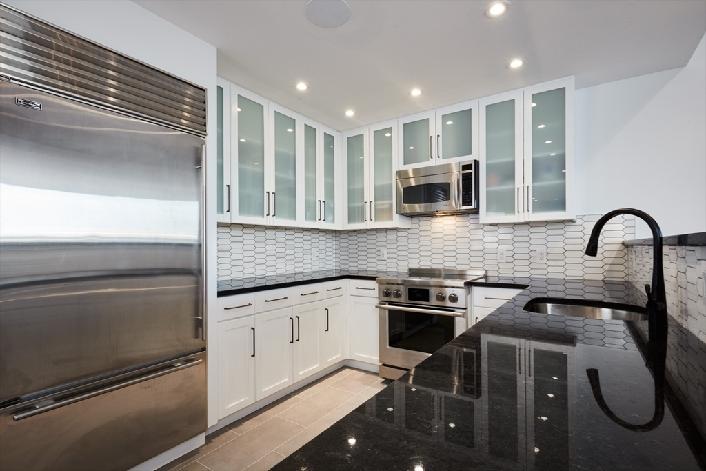 234 Causeway Street, Unit 913/813 Boston, MA 02114 - Photo 18 of 22 a kitchen with granite countertop a stove and a microwave