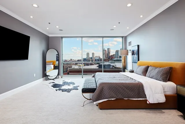 a bedroom with a bed gym equipment and a flat screen tv