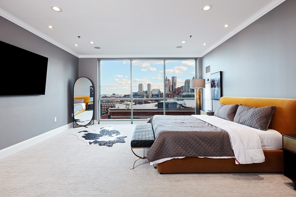 234 Causeway Street, Unit 913/813 Boston, MA 02114 - Photo 2 of 22 a bedroom with a bed gym equipment and a flat screen tv