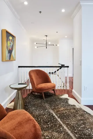 a living room with furniture a rug and white walls