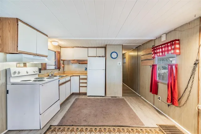 a kitchen with refrigerator and cabinets