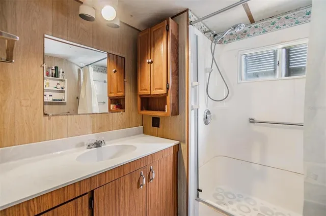 a bathroom with a shower sink and mirror