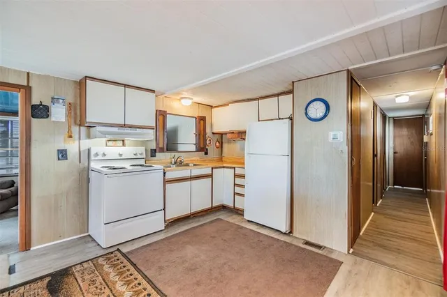 a kitchen with a refrigerator and white cabinets