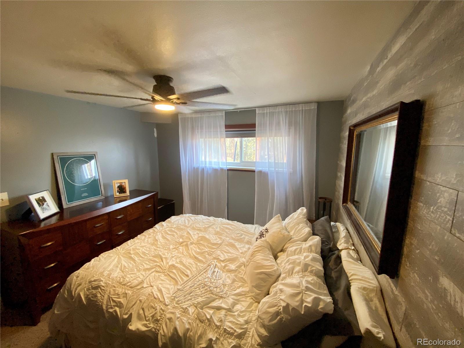 44 Pine Road Golden, CO 80401 - Photo 25 of 35 a bedroom with a bed and a flat tv screen on dresser