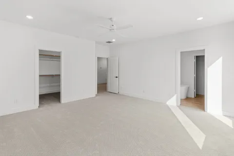 a view of an empty room with closet and a bathroom