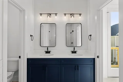 a bathroom with double vanity sinks and a mirror