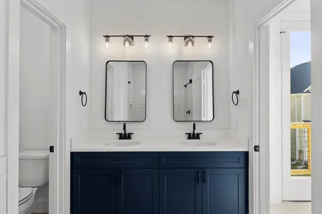 a bathroom with double vanity sinks and a mirror