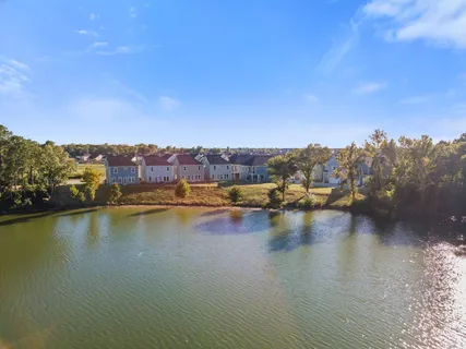 an aerial view of residential houses with outdoor space and lake view
