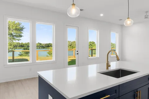 a view of a kitchen island a sink a window and wooden floor
