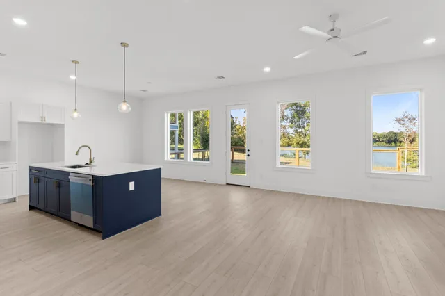a view of a kitchen with a sink a window and wooden floor