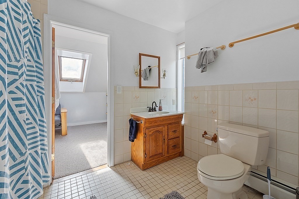 479-483 Gleasondale Road Stow, MA 01775 - Photo 11 of 40 a bathroom with a granite countertop toilet a sink and a mirror