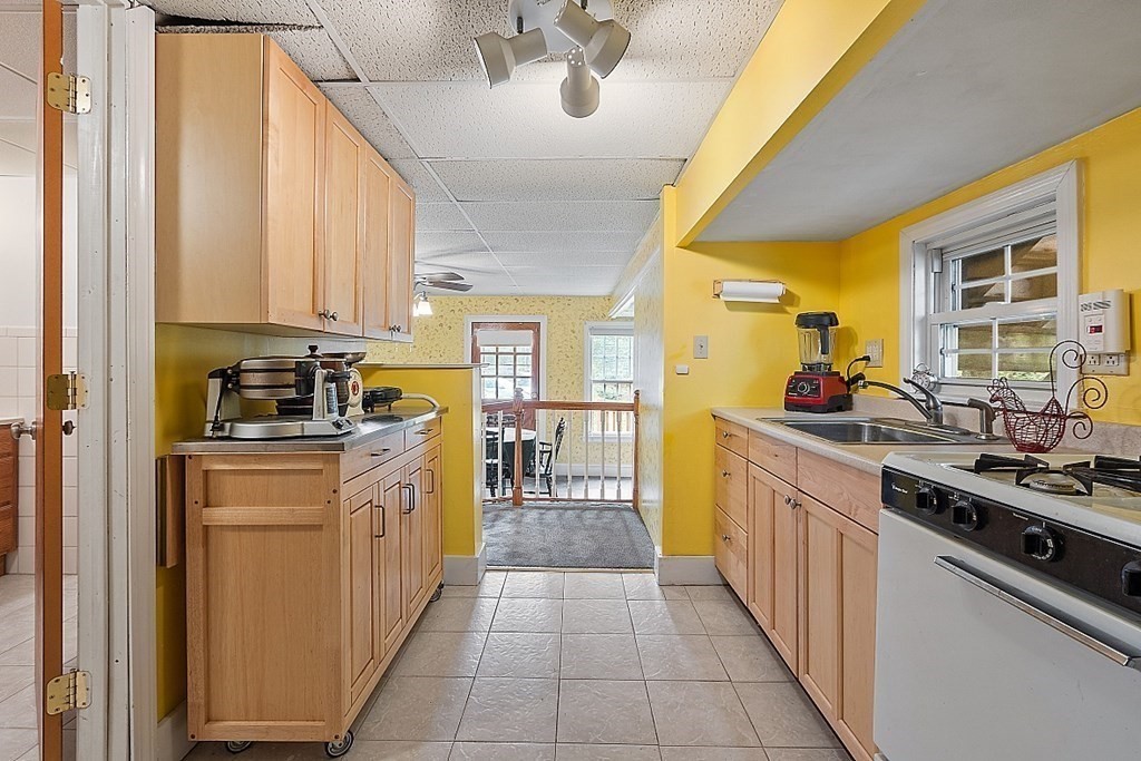 479-483 Gleasondale Road Stow, MA 01775 - Photo 17 of 40 a kitchen with stainless steel appliances a sink counter space cabinets and a window